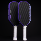Two pickleball paddles with purple and black design on a black background