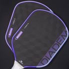 Two pickleball paddles with purple and white design on a black background